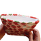 Hands holding a Kindle sleeve with snap to protect Kindle e-readers made with a pink back ground with red and white strawberries.